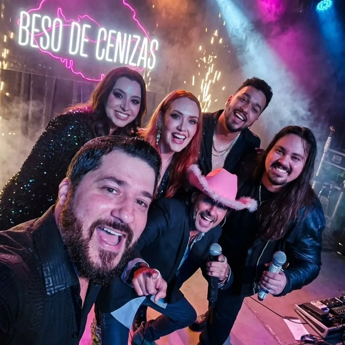 El elenco de VHS tomándose una selfie en el escenario con luces y chispas