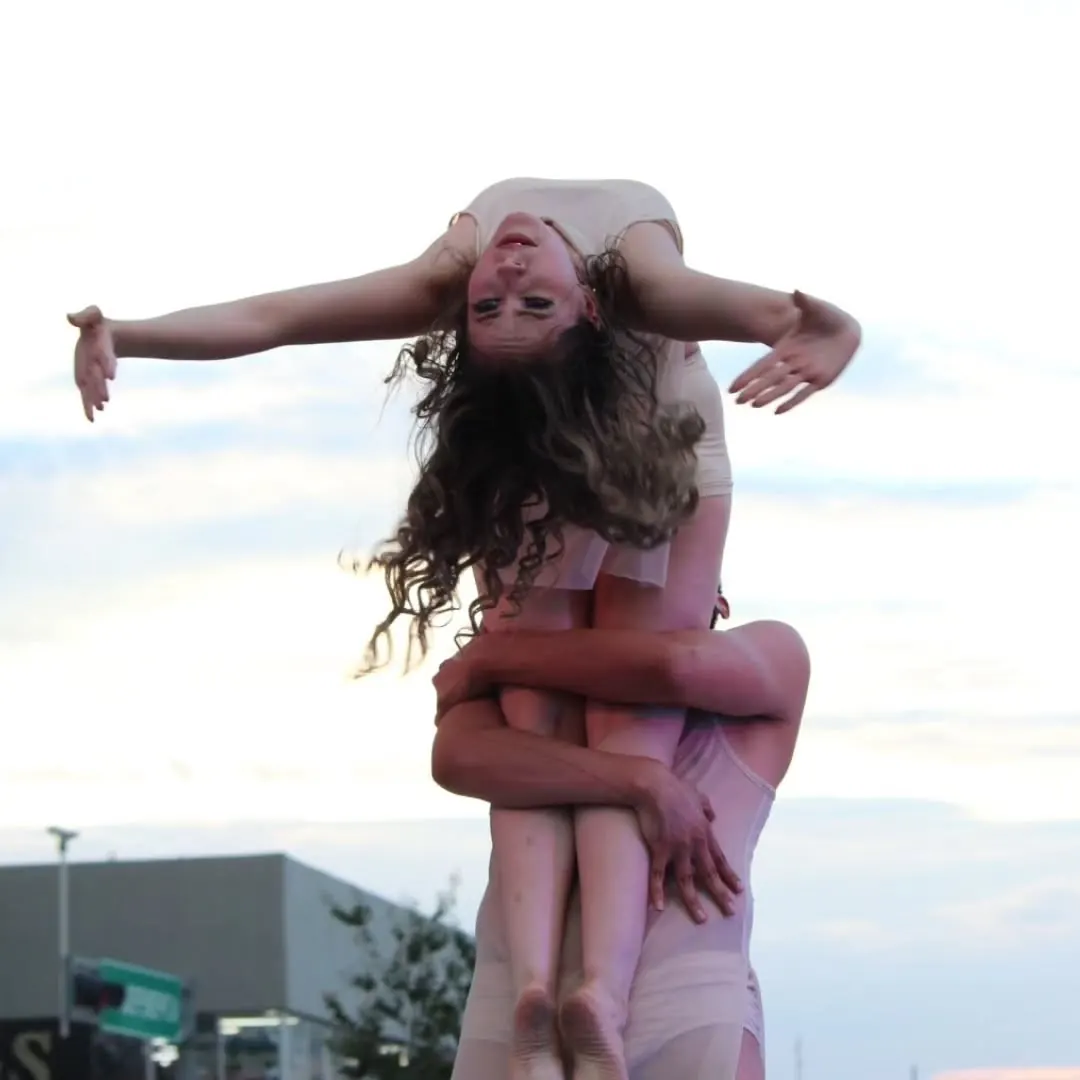 Cargada acrobática del cuerpo de baile contra el cielo