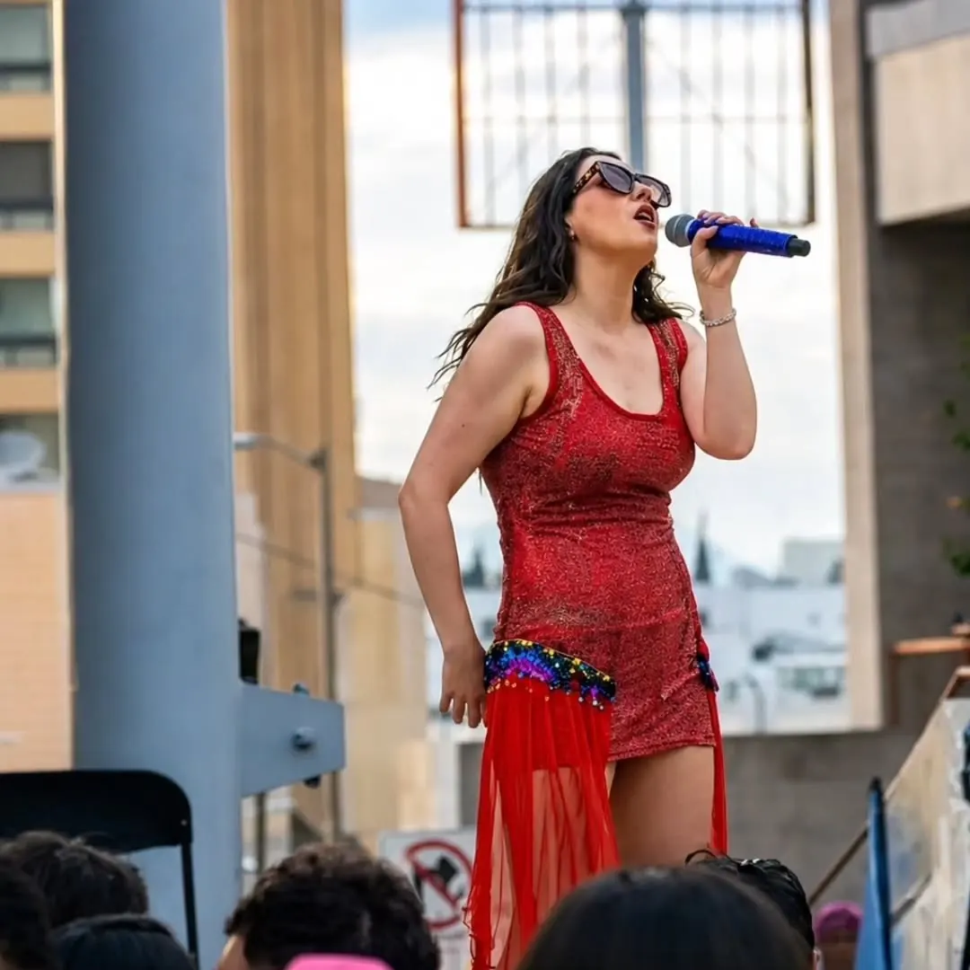 Vocalista con vestido rojo de lentejuelas y lentes oscuros