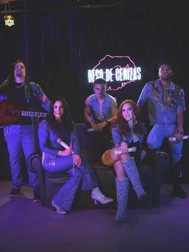 El grupo con vestuario de mezclilla y brillo bajo luz morada